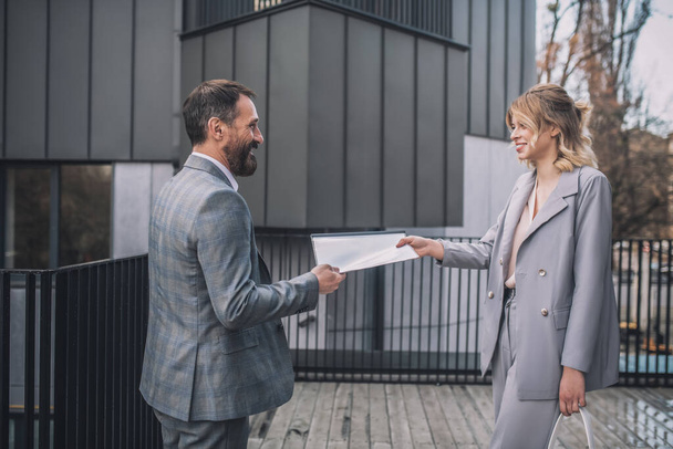 Business man and woman holding document - Foto, afbeelding