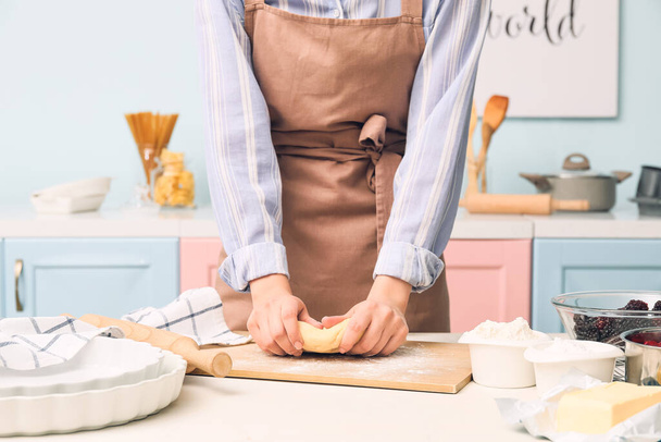 Женщина смешивает тесто на борту на кухне - Фото, изображение