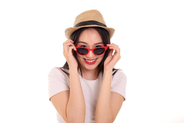 Beautiful young south east Asian woman wearing red frame sunglass eyewear hat pose fashion style white background look around copy text space - Fotografie, Obrázek