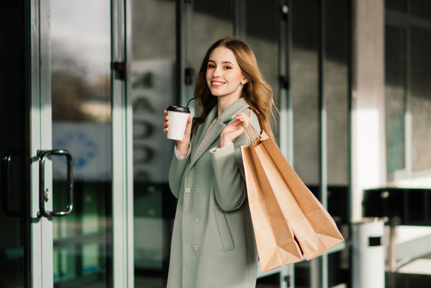 Portrait of cheerful young lady holding shopping bags outdoor - Fotoğraf, Görsel