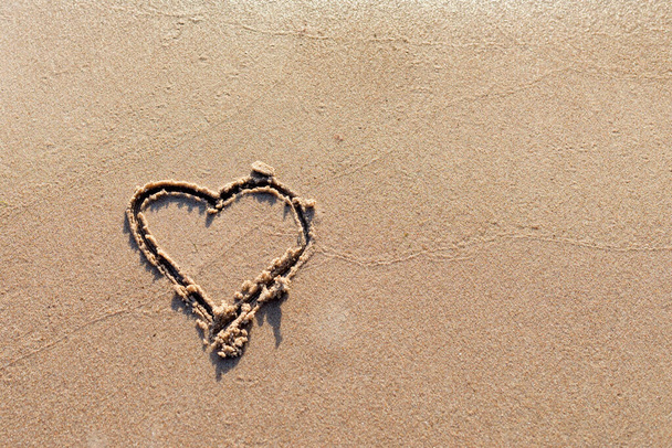 Un corazón dibujado en la arena en una ola Beach.soft del mar.Real amor romántico. verdadero amor.Copiar el espacio. - Foto, imagen