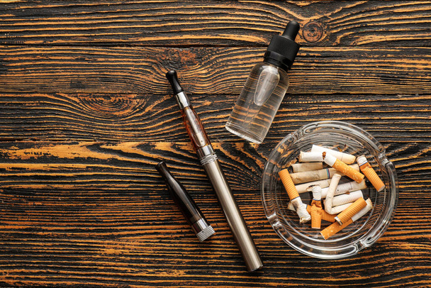 Set pro kouření s cigaretovými pahýly na dřevěném pozadí - Fotografie, Obrázek