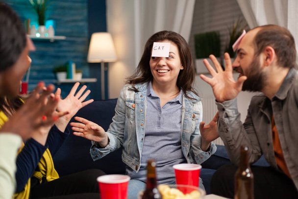 Mixed race friends socializing during entertainment party playing guess who - Φωτογραφία, εικόνα