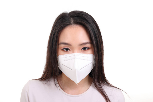Beautiful young south east Asian woman wearing N95 anti virus bacterial surgical face mask on white background look forward - 写真・画像