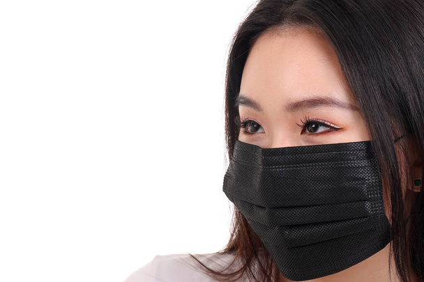 bela jovem sudeste asiático mulher vestindo preto três ply anti vírus cirúrgico máscara facial no fundo branco - Foto, Imagem