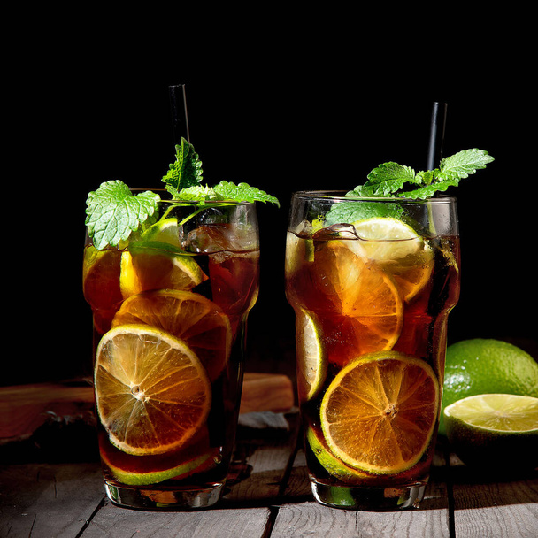 Fresh made longdrink Cuba libre cocktail on dark background. Front view - 写真・画像