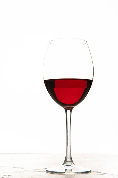 Young woman holding glass of red wine on white background. Hand with black polish. - Photo, image
