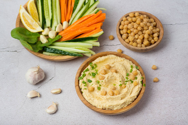 kikkererwt hummus met groenten op grijze achtergrond - Foto, afbeelding