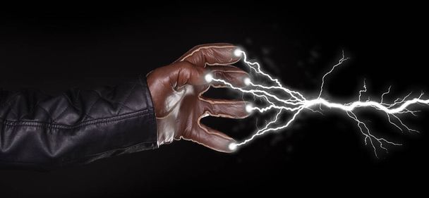 Hand schießt Blitz ab - Dunkel und geheimnisvoll, isoliert auf schwarz - Foto, Bild