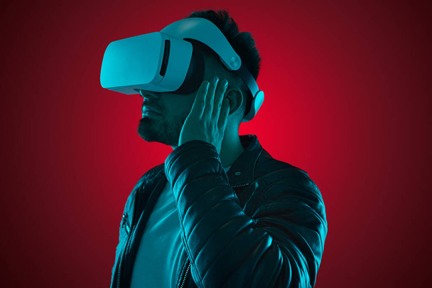 Serious man in VR headset and earbuds - Photo, image
