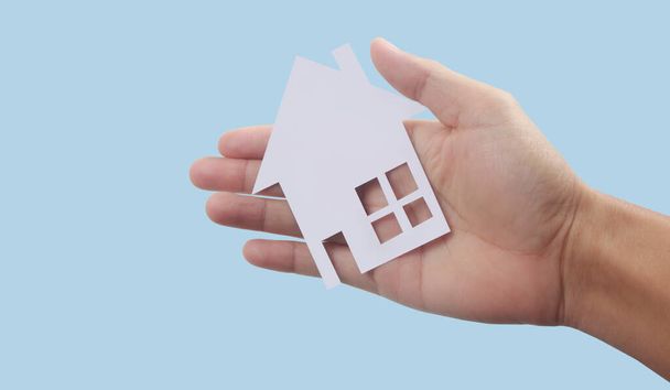 Handen houden papieren huis, gezinswoning en bescherming van het verzekeringsconcept - Foto, afbeelding