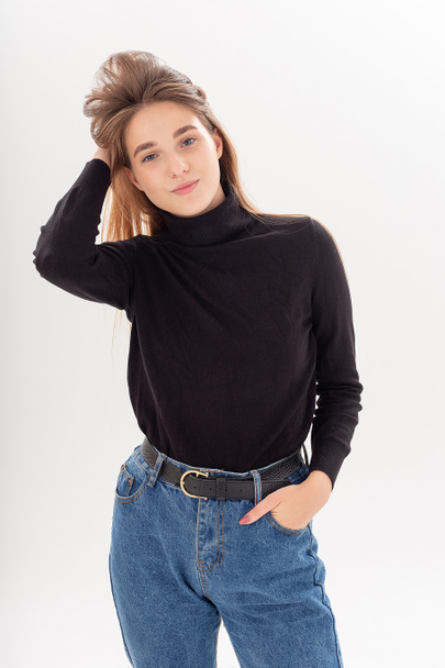 young attractive caucasian woman with long hair in black turtleneck, blue jeans - Photo, image