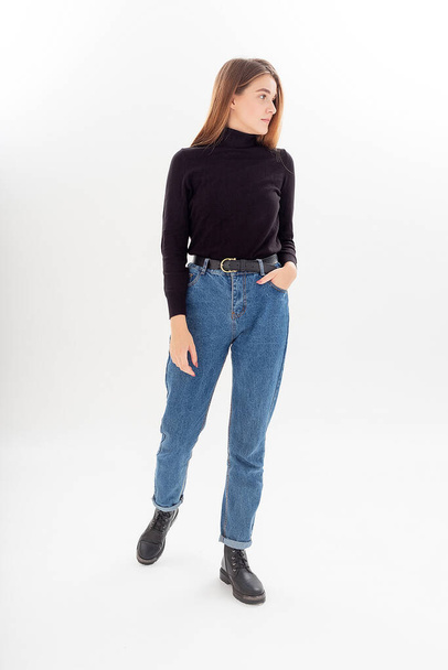 young attractive caucasian woman with long hair in black turtleneck, blue jeans - Foto, imagen