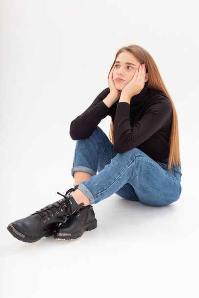 young attractive caucasian woman in black turtleneck, blue jeans at white studio - Foto, immagini