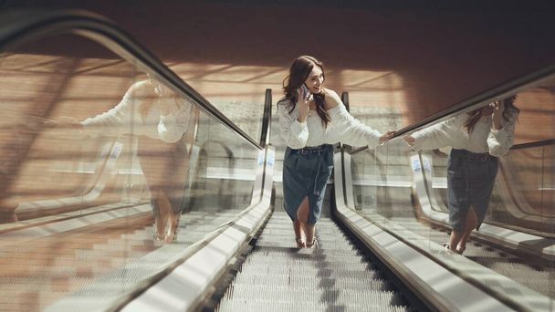 happy young woman using smartphone on escalator  - Foto, immagini