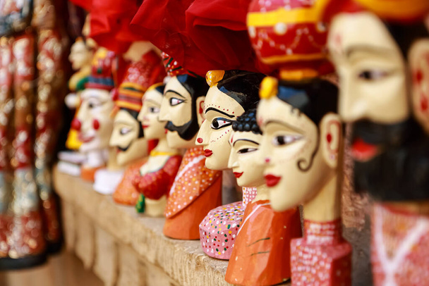 Marionnettes colorées en forme de visage humain portant des vêtements colorés accrochés au mur au Rajasthan, Inde, le 21 février 2018 - Photo, image