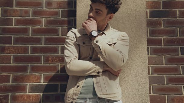 man in beige jacket looking away near building outdoors - Photo, image