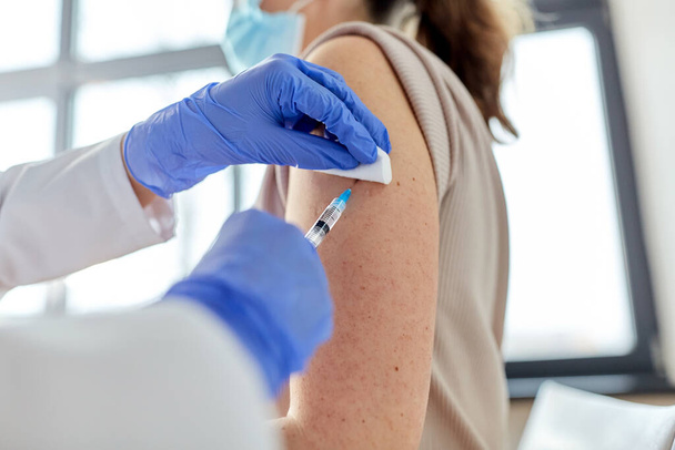 female doctor with syringe vaccinating patient - Φωτογραφία, εικόνα