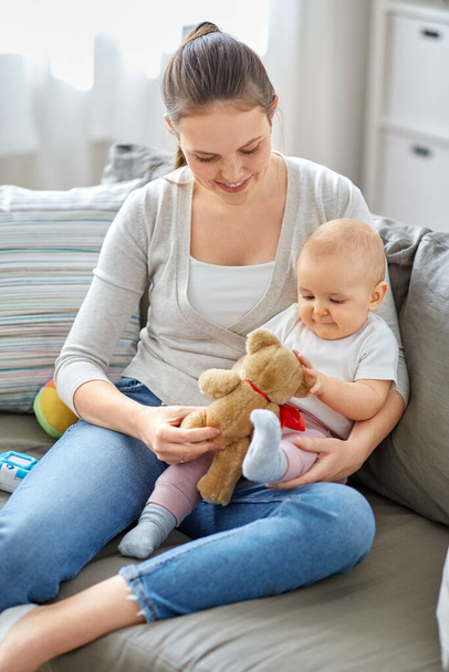 mother with baby playing with teddy bear at home - Foto, Imagem