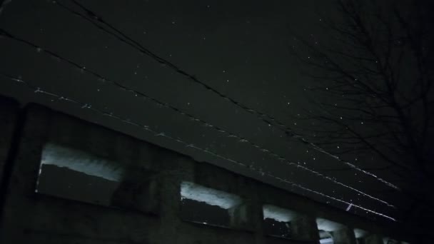 prison barbed wire over concrete fence at cold dark winter night during snowfall - Footage, Video