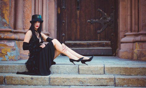 Gothic lady in a luxurious glamorous retro look for Halloween. Beautiful citizen in vintage clothing with feathers and fine accessories of handmade work. Ideas for the Halloween holiday - Foto, Imagem