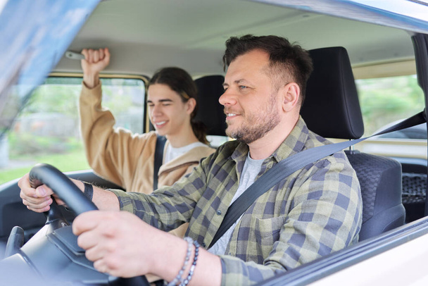 Portrait of father and teenage son together, man driving car - Photo, Image