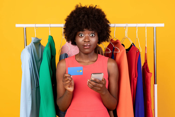 衝撃的なアフリカ系アメリカ人女性は電話とクレジットカードを持っています,スタジオ - 写真・画像