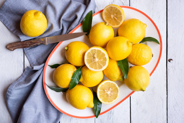 Свіжі і стиглі лимони з листям на білому дереві
 - Фото, зображення
