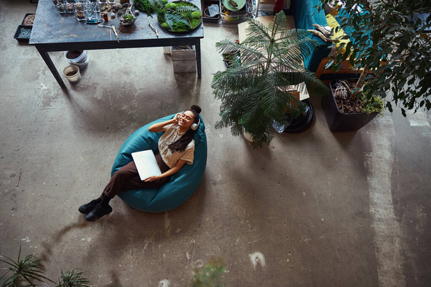 Florist lying with closed eyes in a bean bag chair - Φωτογραφία, εικόνα