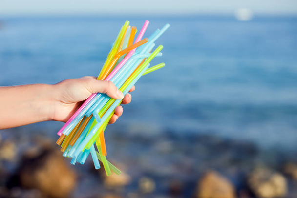 Close Up Of HandsHolding plástico palhas poluindo praia. Conceito de poluição ambiental - Foto, Imagem