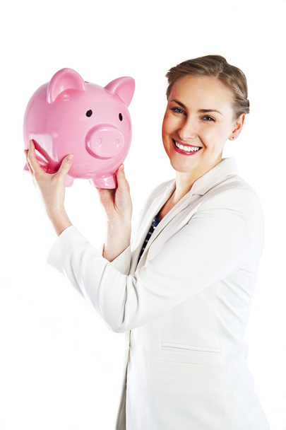 Happy businesswoman holding piggy bank against white background - Фото, изображение