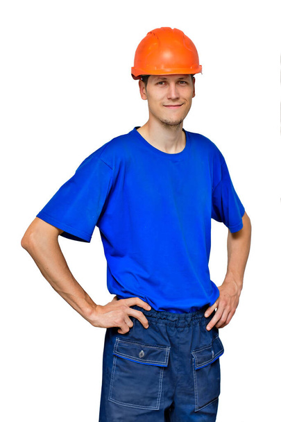 Портрет молодого красивого чоловіка в будівельному шоломі і робочий одяг ізольовані на білому тлі
.  - Фото, зображення