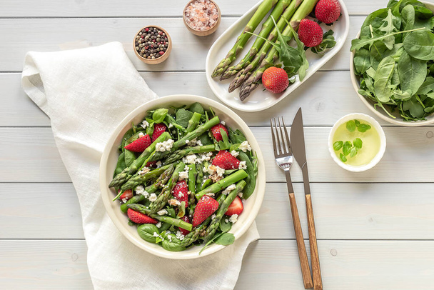 Aardbei, spinazie, groene asperges, arugula, en feta kaas detox salade, kopieer ruimte voor uw tekst. Gezond, vegetarisch, seizoensgebonden voedsel. Schoon eten. - Foto, afbeelding