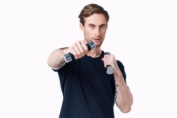 手にダンベルを持つ男スポーツフィットネスタトゥー彼の腕と白い背景に - 写真・画像