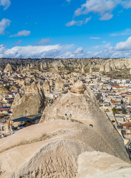 Goreme, Turkey - March 20, 2021 - vertical view of the town of Goreme in Cappadocia, Turkey with fairy chimneys, houses, and unique rock formations seen from sunrise point - Foto, imagen