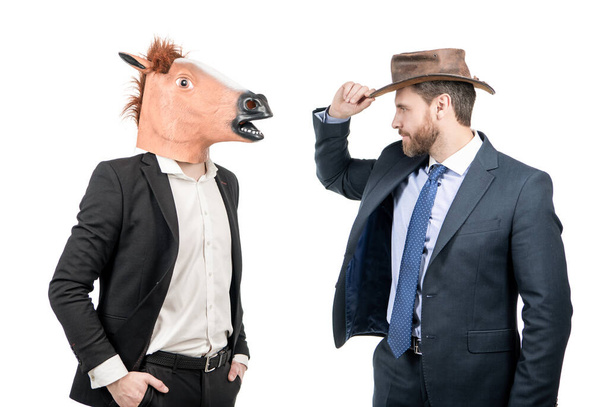 Ковбой и бизнесмен в маске лошадиной головы на костюмированной вечеринке, корпоративный Хэллоуин - Фото, изображение