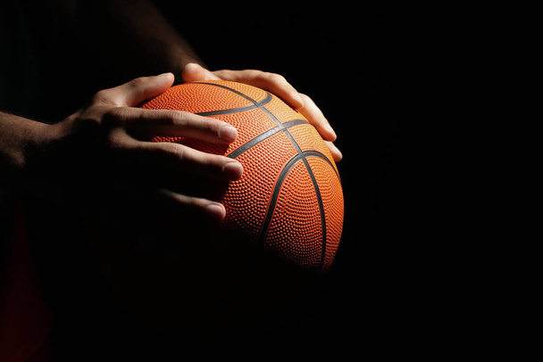 Basketball player with ball on black background, closeup. Space for text - Фото, зображення