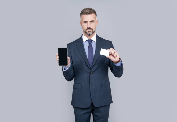 Olgun adam danışmanı kredi kartı veya banka kartı ve akıllı telefon kopyalama alanı, çevrimiçi bankacılık gösteriyor. - Fotoğraf, Görsel