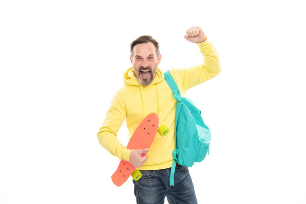 mature happy man carry backpack and penny board. smiling senior guy back to school - Photo, image