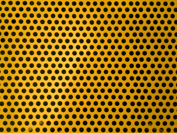 Kulaté otvory ve žluté perforované kovové desce - Fotografie, Obrázek