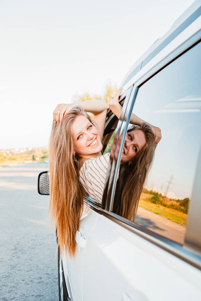young pretty woman driving car on sunset. warm sunny day - 写真・画像