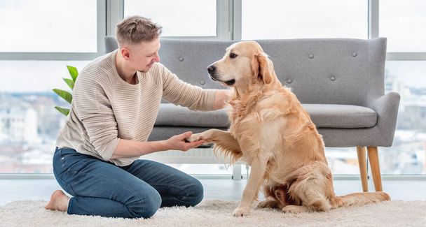 Man sitting with golden retriever dog - Foto, Bild