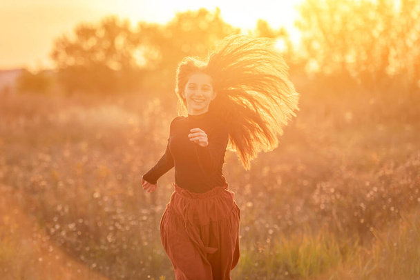 Smiling teenage girl on autumn field - Foto, Imagen
