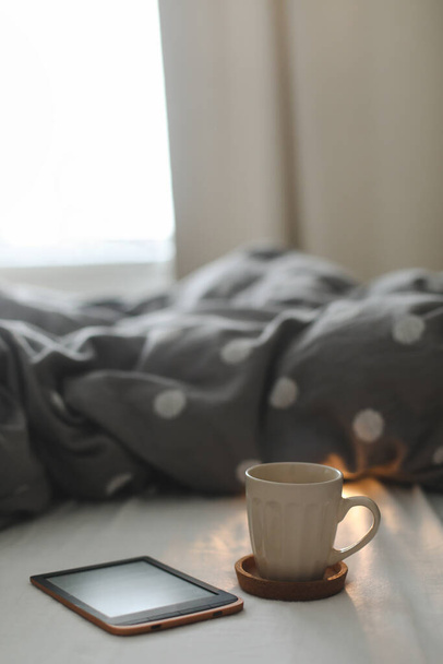 E-book and a cup of coffee in bed on the sheets. Good morning. Breakfast in bed - Photo, Image