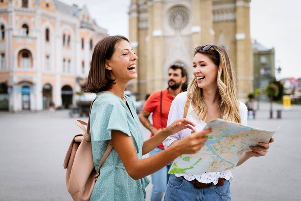 Happy traveling women tourists sightseeing with map in hand - Foto, imagen
