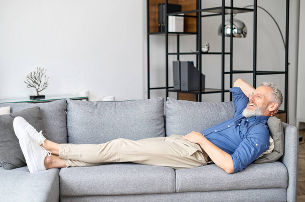 Middle-aged man lying down on the sofa and rests - Foto, imagen