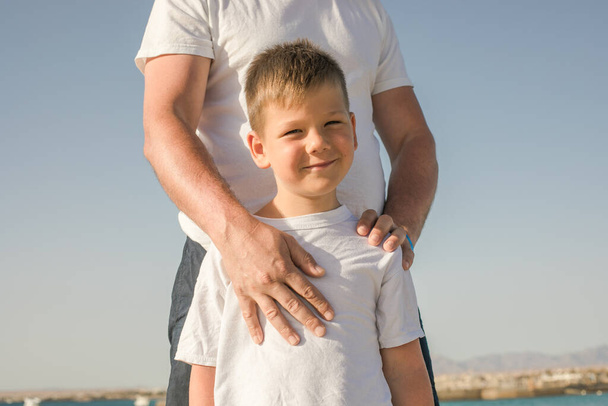 父と息子は海の休暇を一緒に過ごす。若い男は、小さな男の子のビーチ父日歩いてください。1人の子供を持つ家族。パパと幸せな子供時代. - 写真・画像