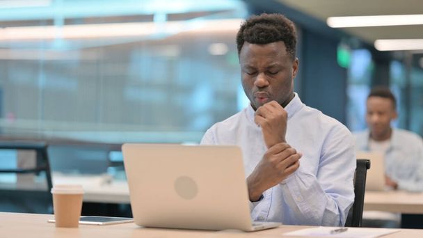 Afrikaanse zakenman met laptop met pijn in de pols  - Foto, afbeelding