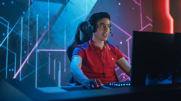 Professional eSports Gamer Playing in Computer Video Games. Background Stylish Graphics. Online Championship Tournament Streaming Event. Portrait Semi-Side View Shot - Foto, imagen
