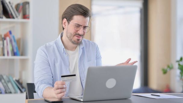 Échec du paiement en ligne sur ordinateur portable par l'homme à lunettes  - Photo, image